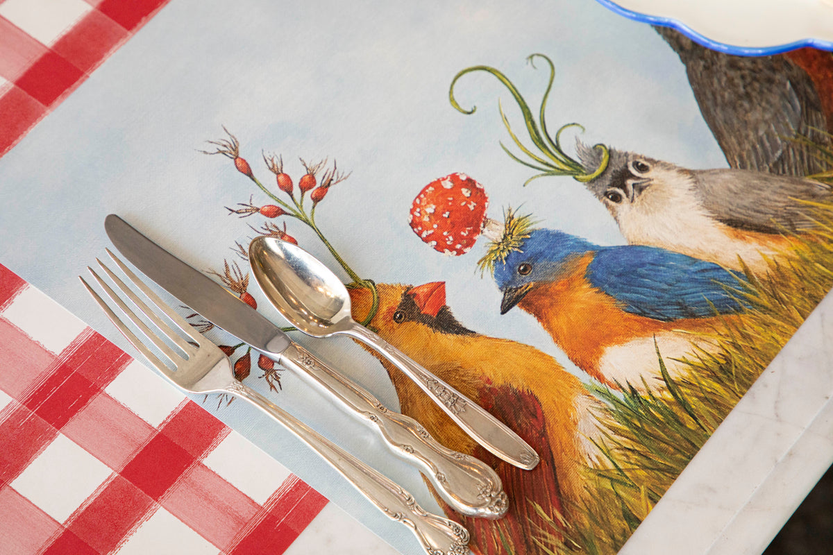 Silverware arranged on a napkin with a bird illustration.