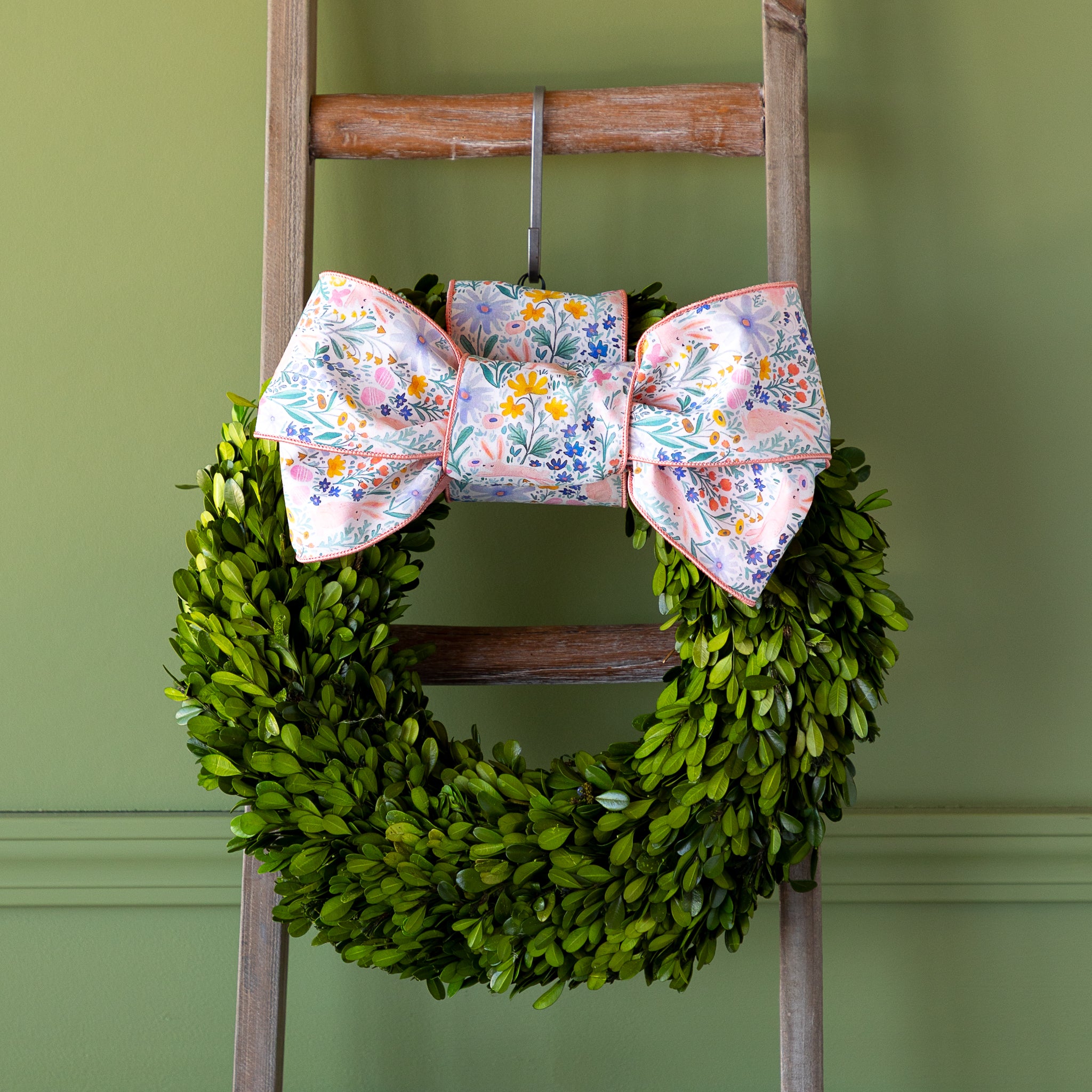 Poplin Watercolor Floral Bunny Ribbon tied in a bow atop a boxwood round wreath.