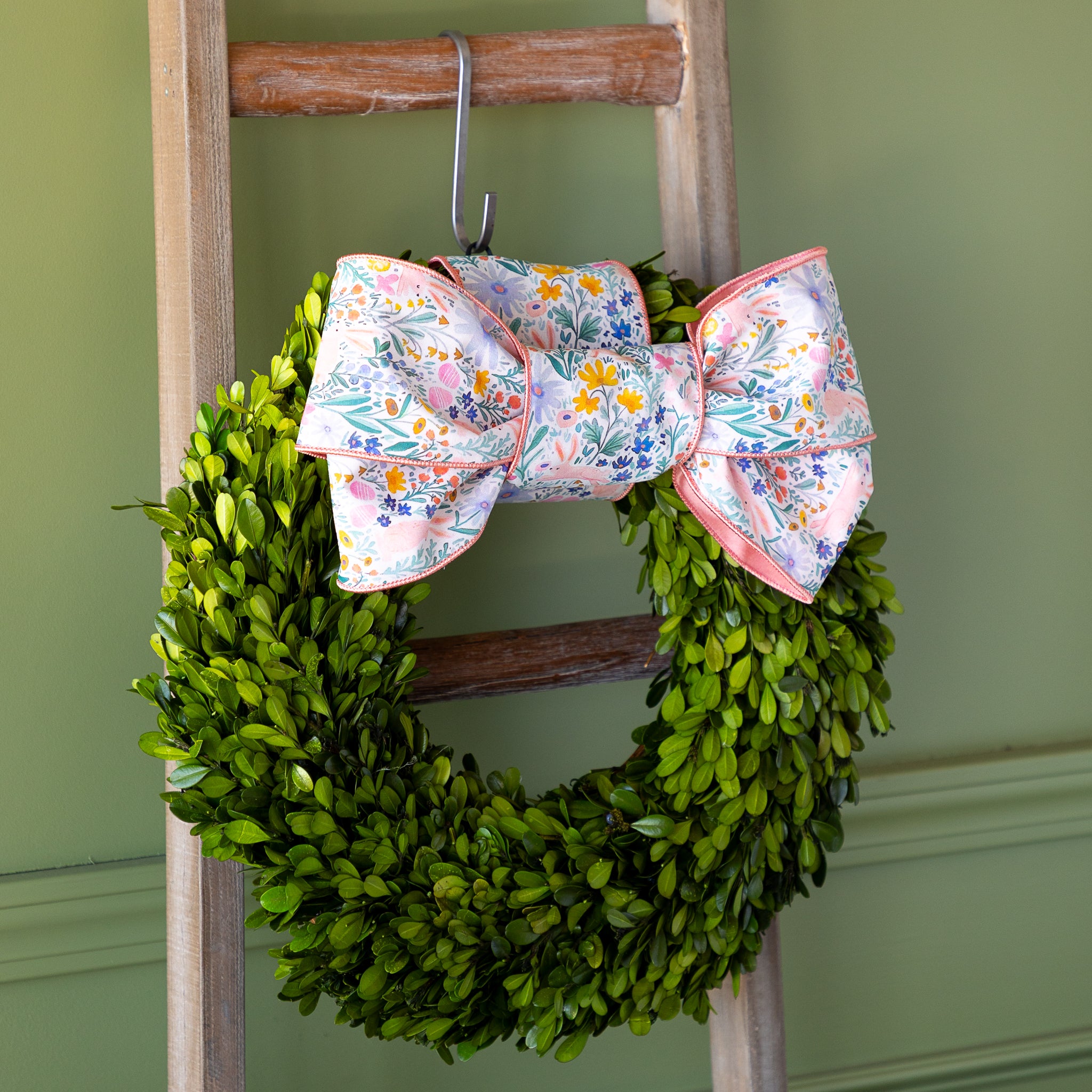 Poplin Watercolor Floral Bunny Ribbon tied in a bow atop a boxwood round wreath.