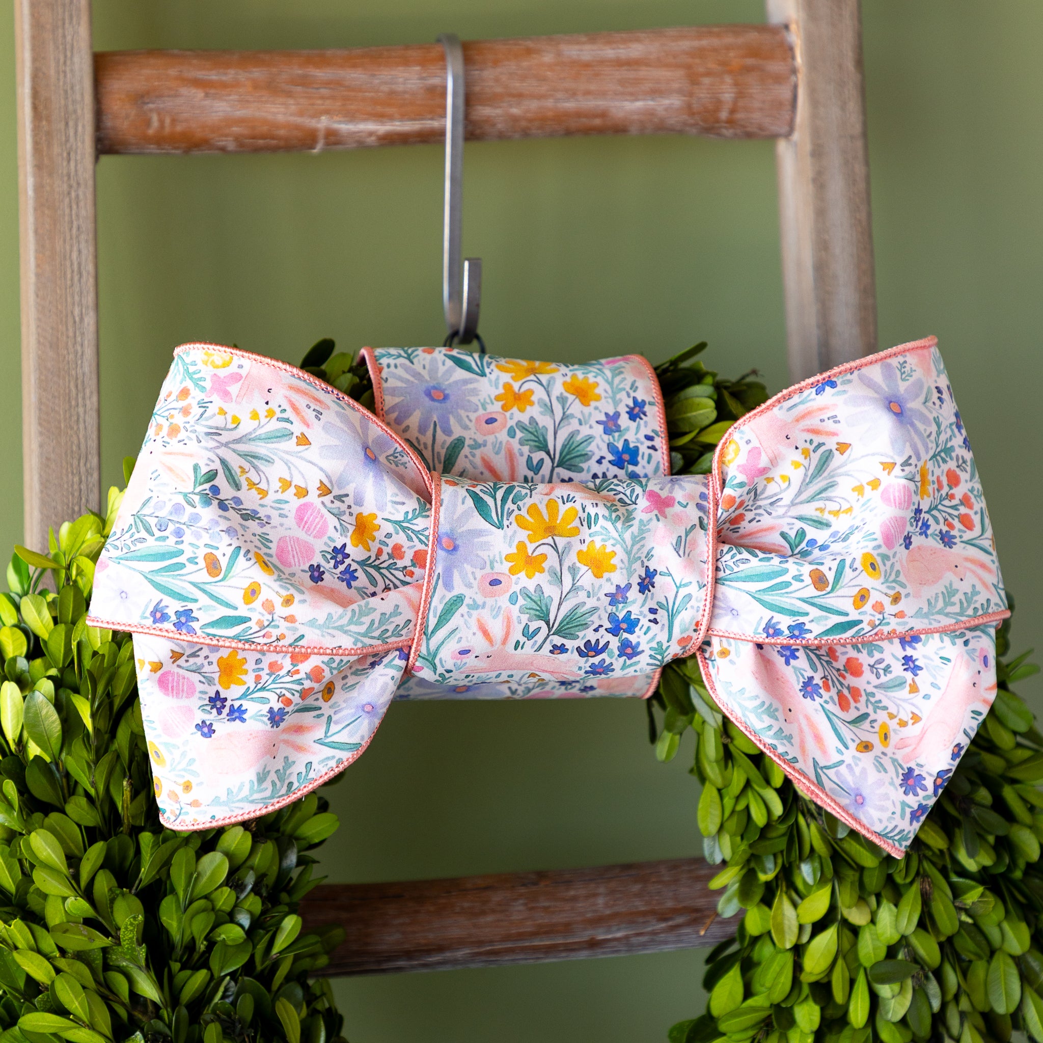 Poplin Watercolor Floral Bunny Ribbon tied in a bow atop a boxwood round wreath.