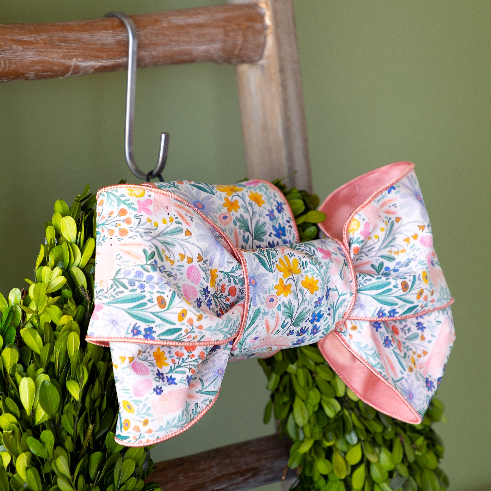 Poplin Watercolor Floral Bunny Ribbon tied in a bow atop a boxwood round wreath.