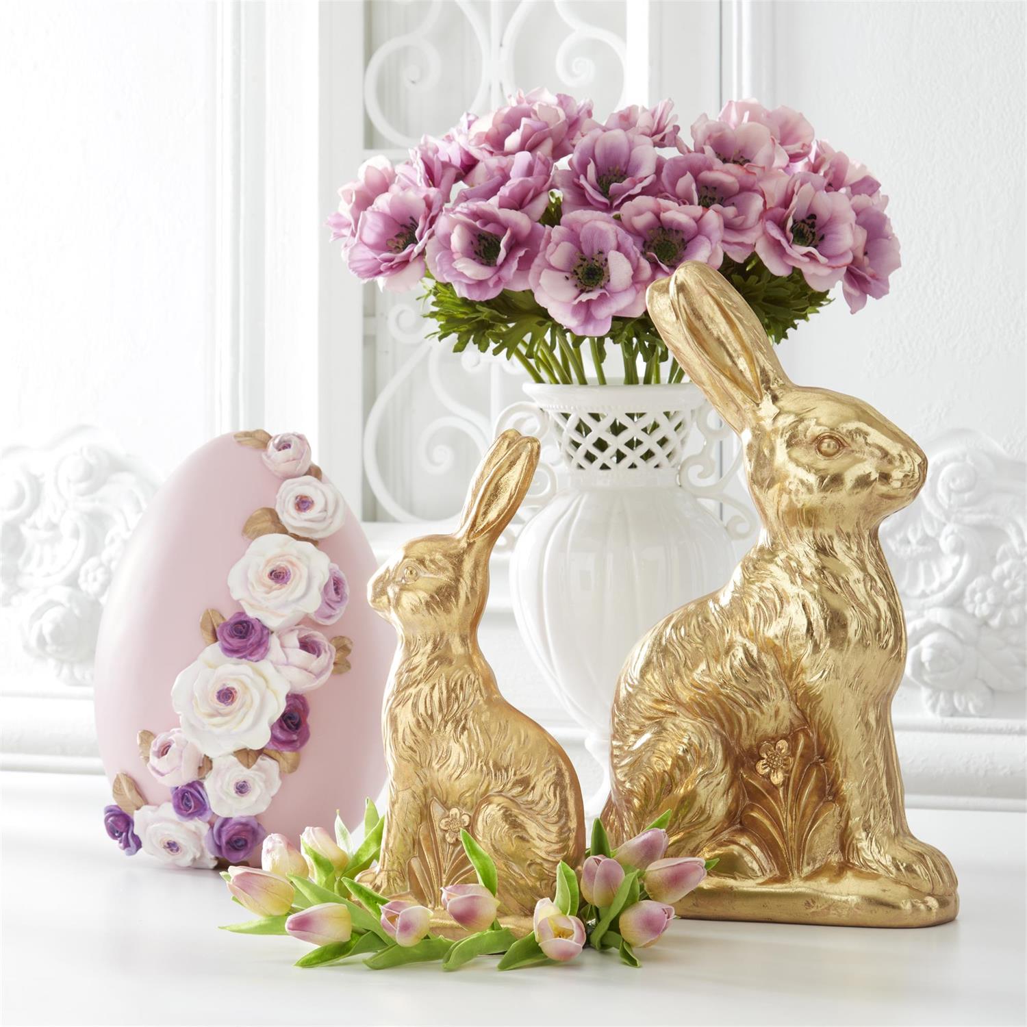 Decorative bunny figurines with floral details on a white surface.