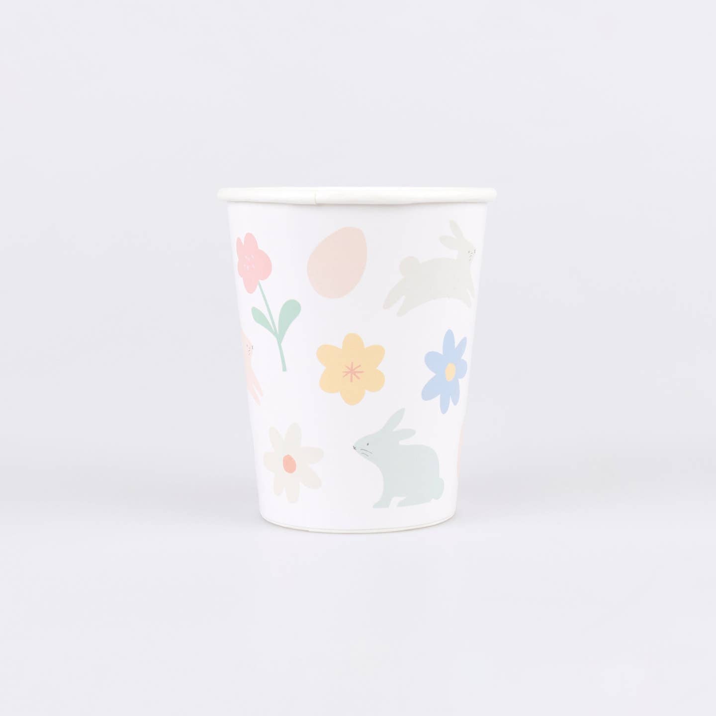 Paper cup with floral and bunny design on a white background.
