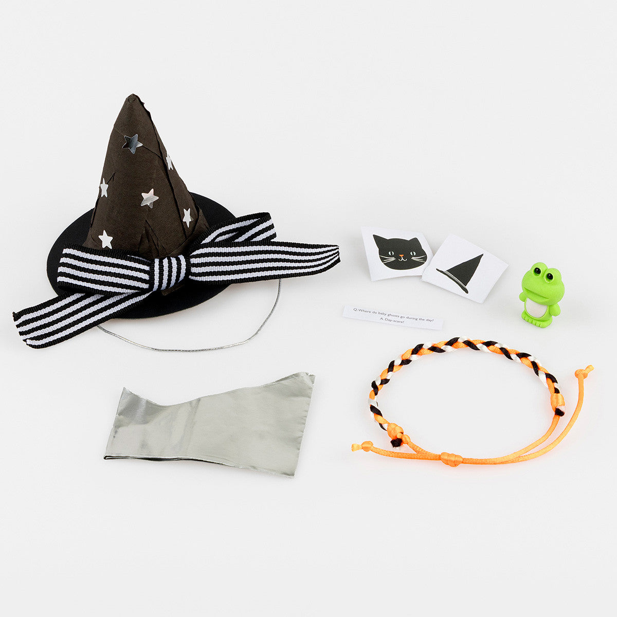 Gifts inside surprise hats, a small green frog, a friendship bracelet of orange, black and white and 2 stickers one a cat and one a witch hat.