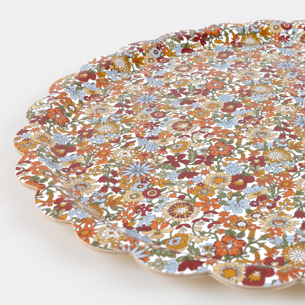 Round Liberty of London floral patterned tray with scalloped edge on a white background.