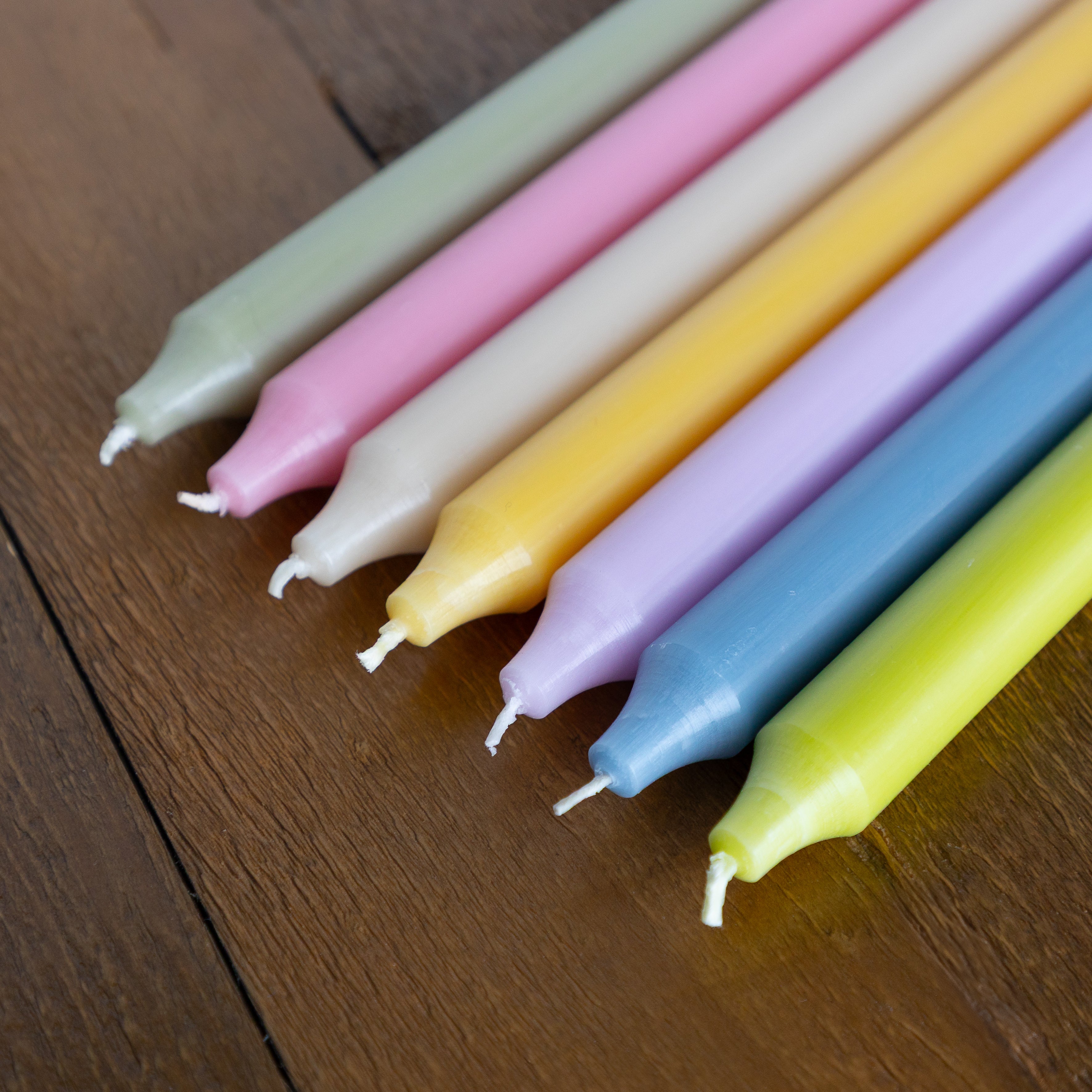 Set of colorful candles on a wooden surface.