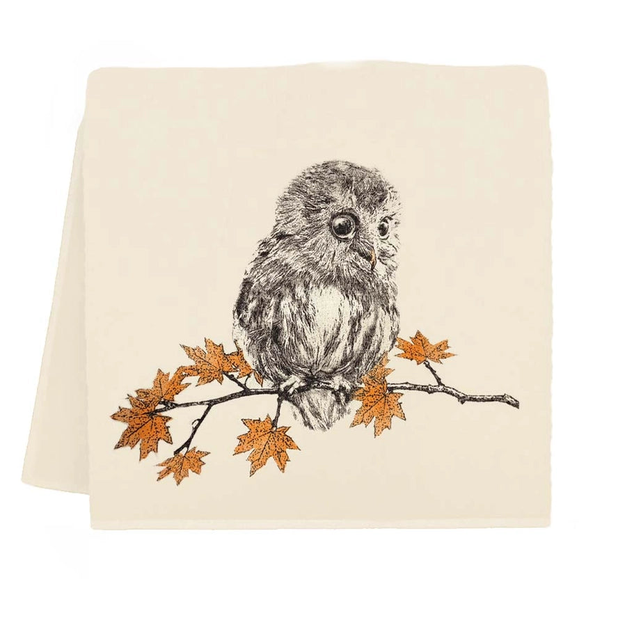 A square cream-colored fabric napkin or tea towel featuring a detailed black and white sketch of a small owl perched on a branch with orange autumn leaves.