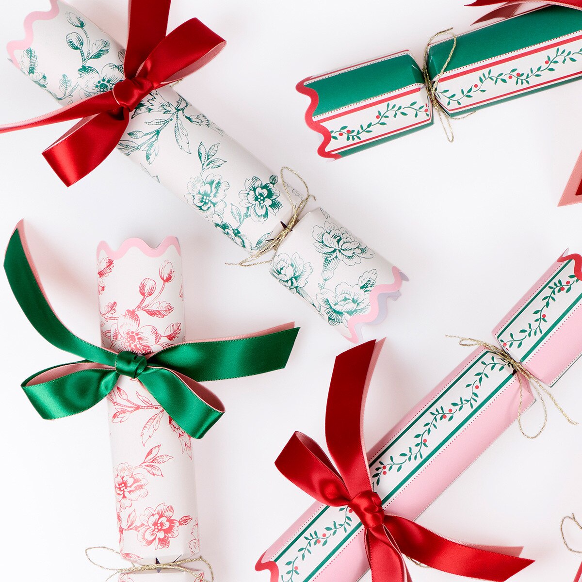 Decorative Christmas crackers with red and green ribbons on a white background
