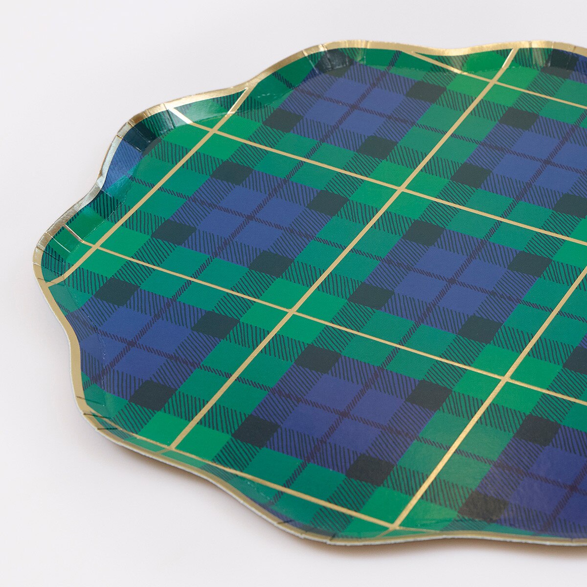 A scalloped ceramic paper plate with a green and blue tartan plaid pattern and a gold metallic rim, shown on a white background.