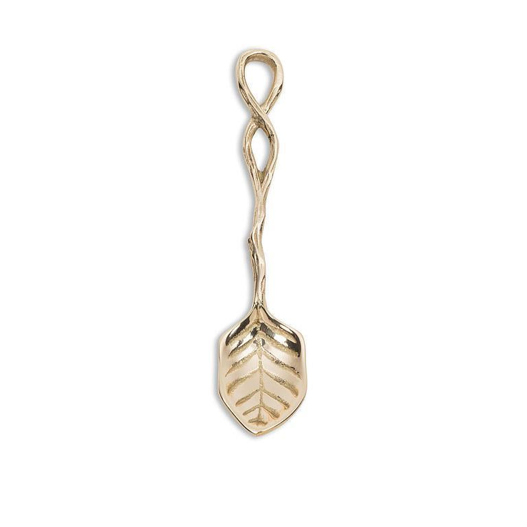 Gold spoon that mimics a leaf design on a white background.