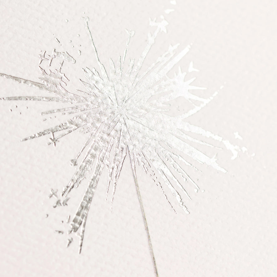 A close-up of a white textured surface with a delicate, frosty starburst or snowflake-like pattern radiating outward.