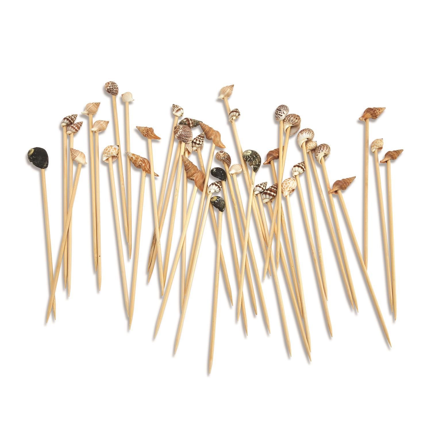 Set of toothpicks with decorative shell ends on a white background.