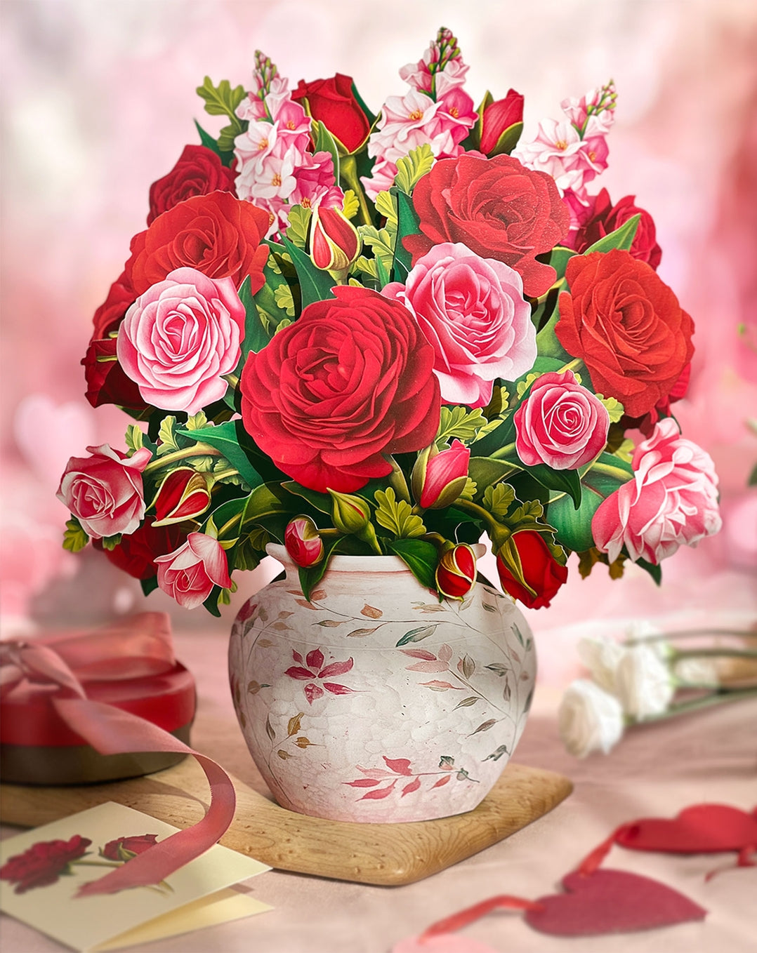 Bouquet of red and pink roses in a decorative vase on a blurred background