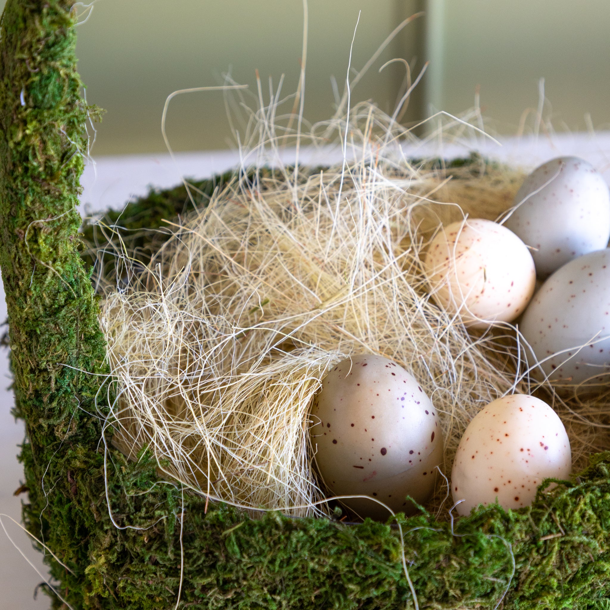 Basket filler with speckled eggs in a moss basket.