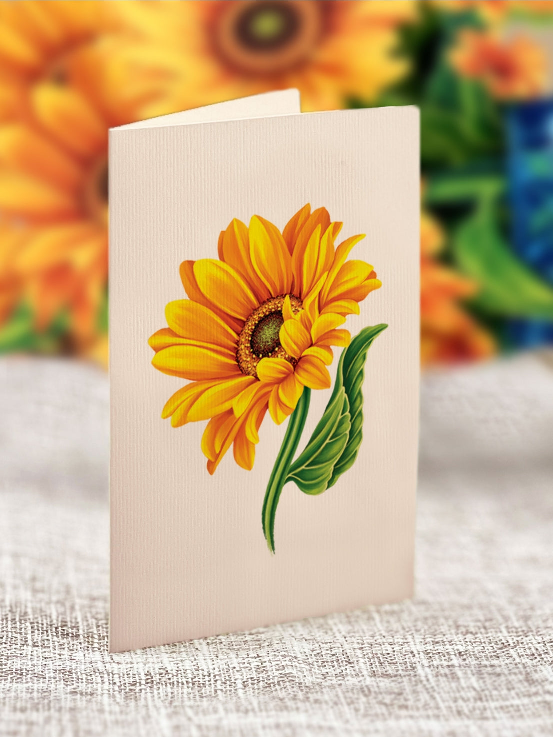 Card with a sunflower design on a textured surface with a floral background