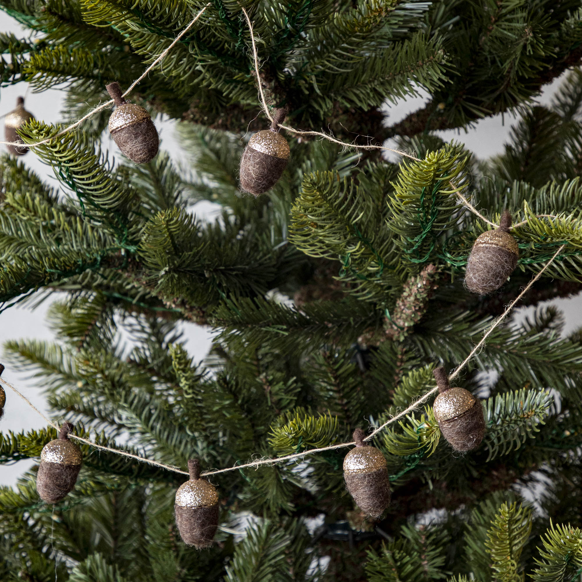 Woolen acorn garland strewn around a tree.