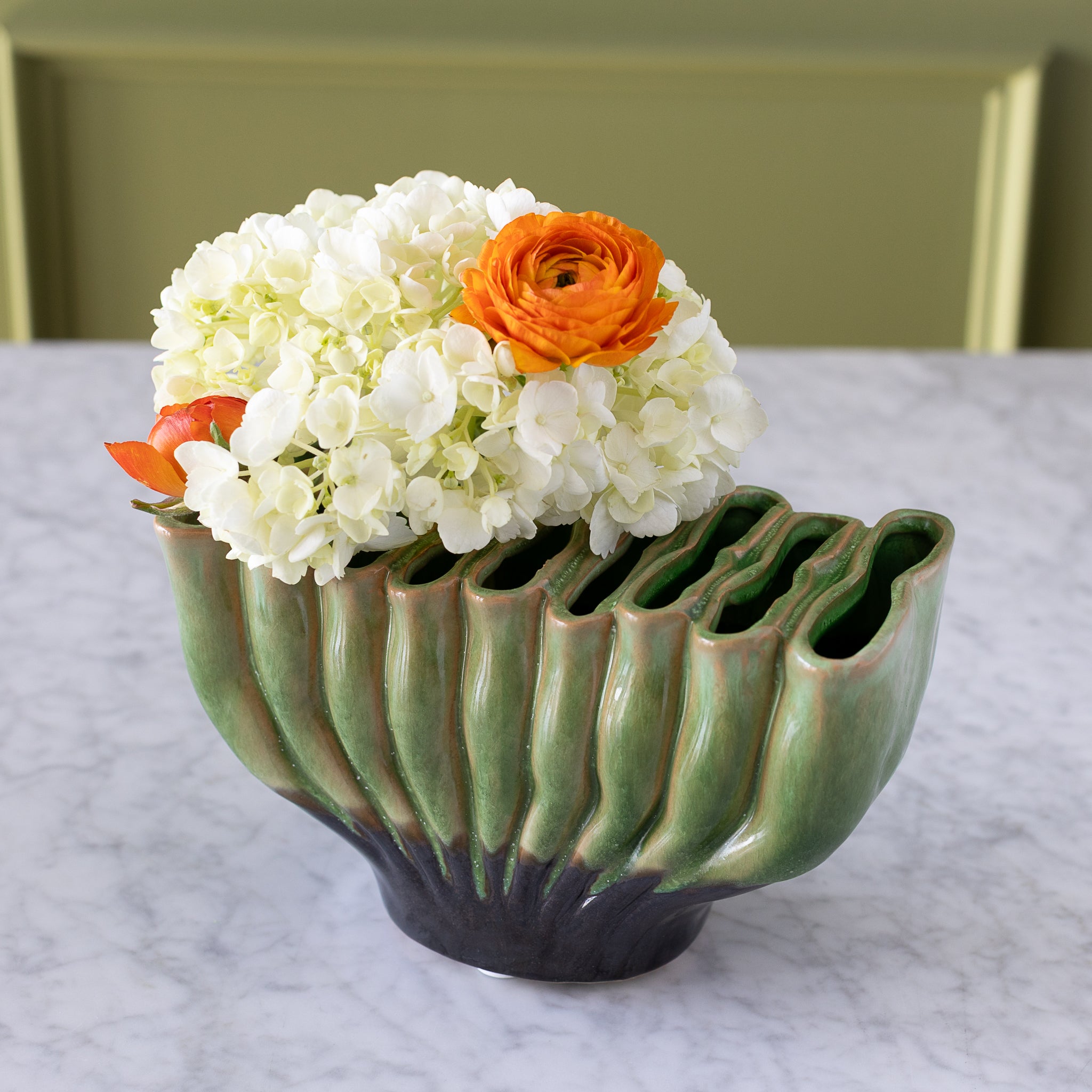 9-hole Ceramic Fakir Green Vase with flowers in it.