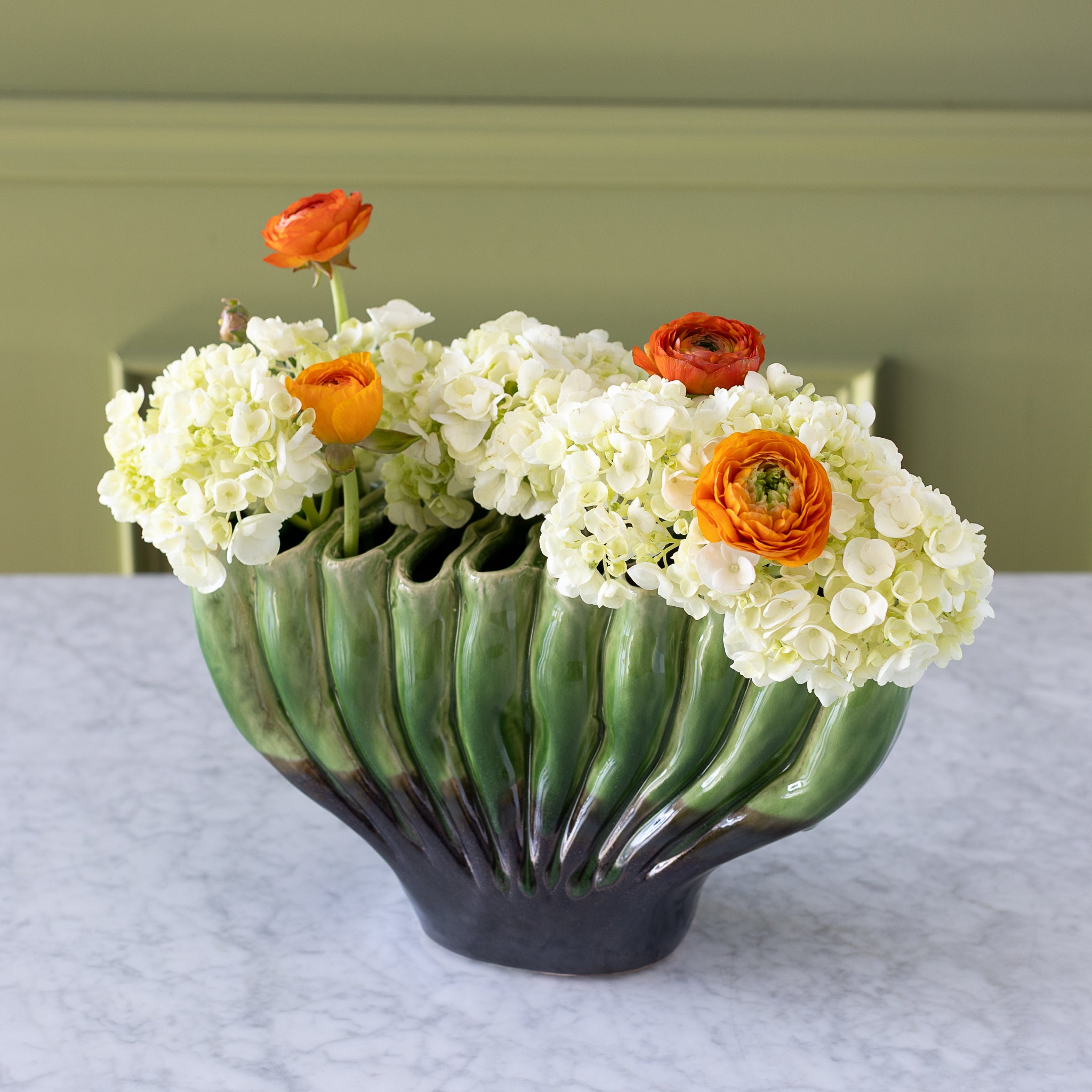 10-hole Ceramic Fakir Green Vase with flowers in it.