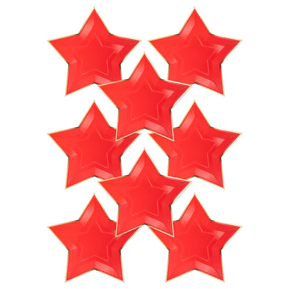 Red star shaped paper plates with gold foil rim on a white background.