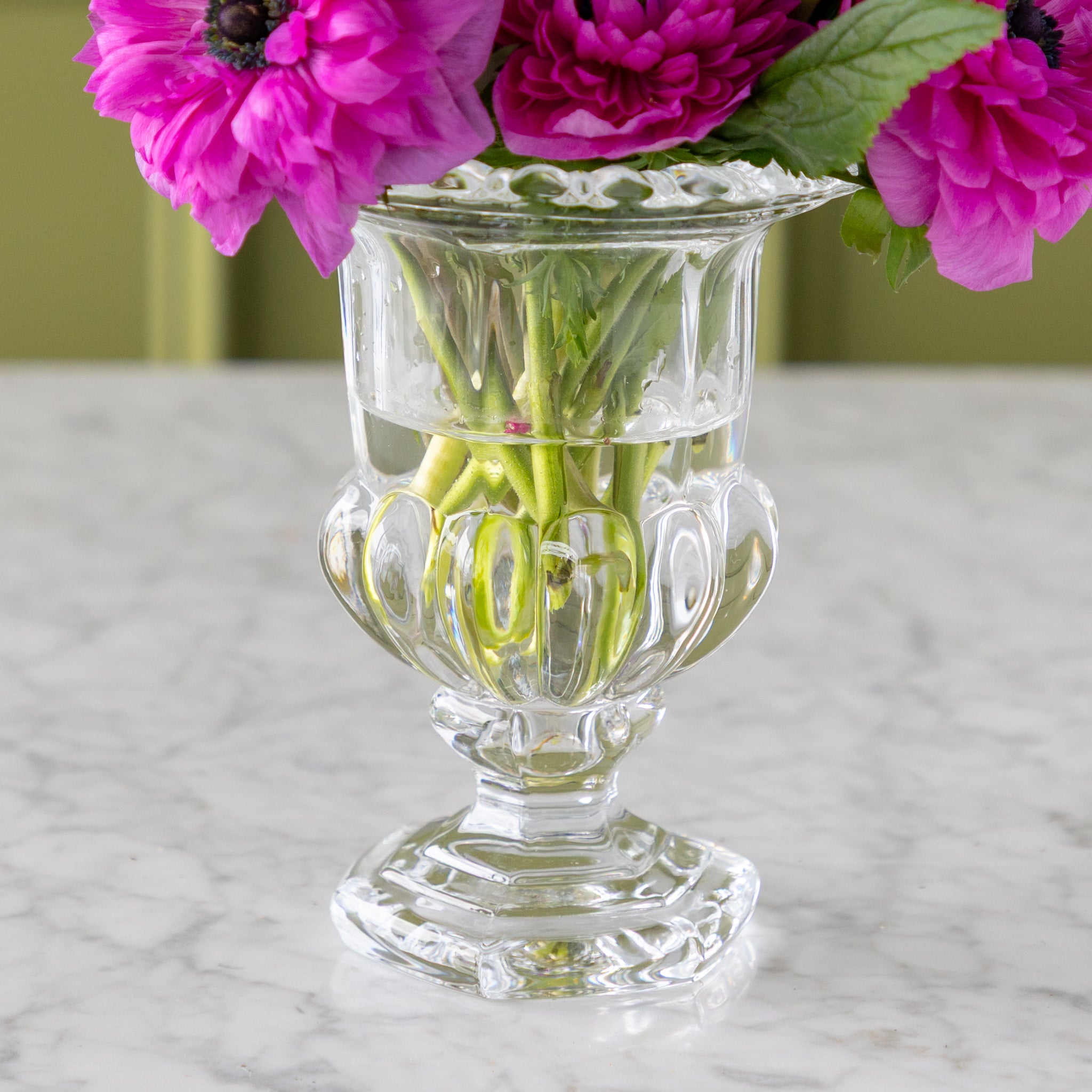 Clear glass vase with pink flowers on a marble surface