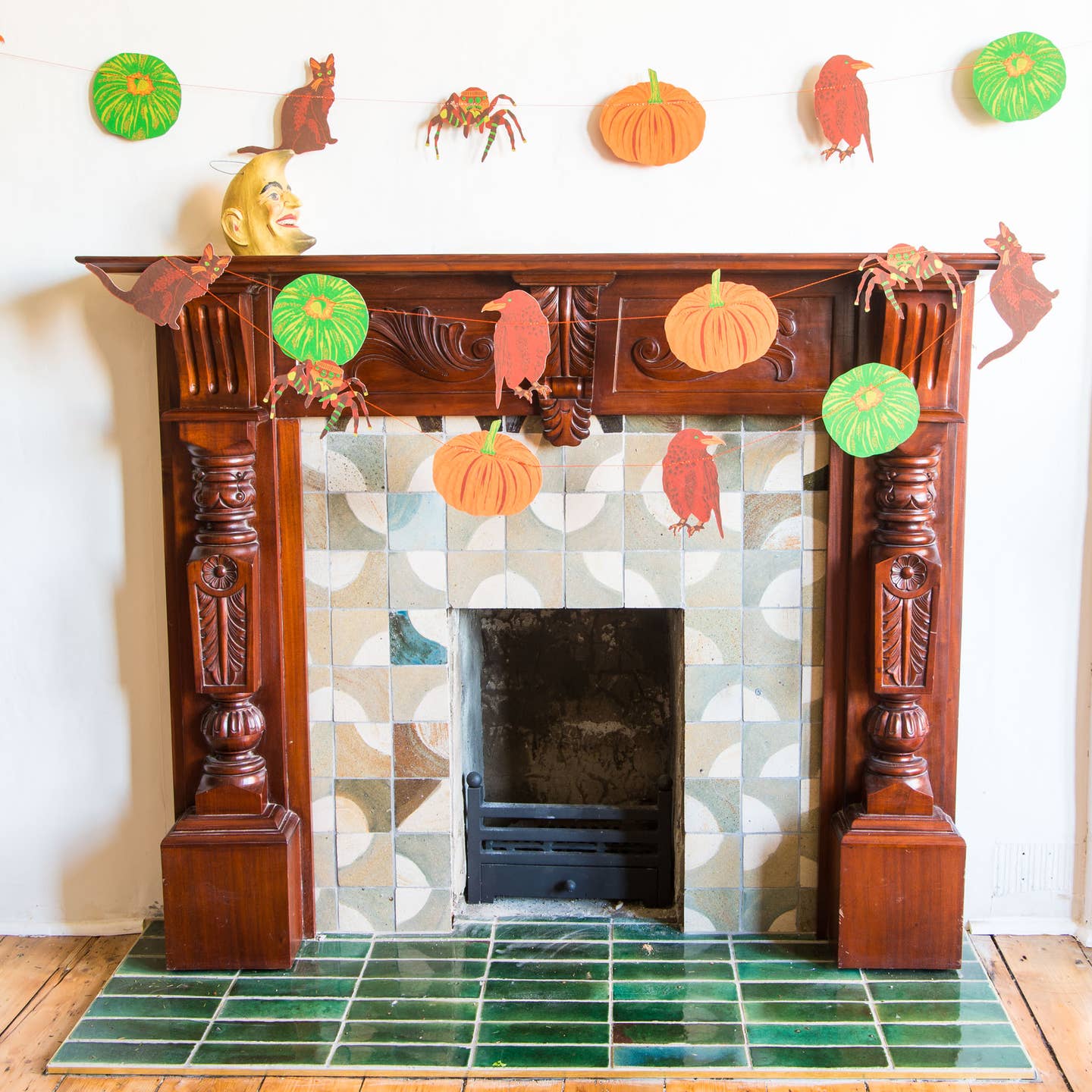 Pumpkin garland hanging on a mantle.