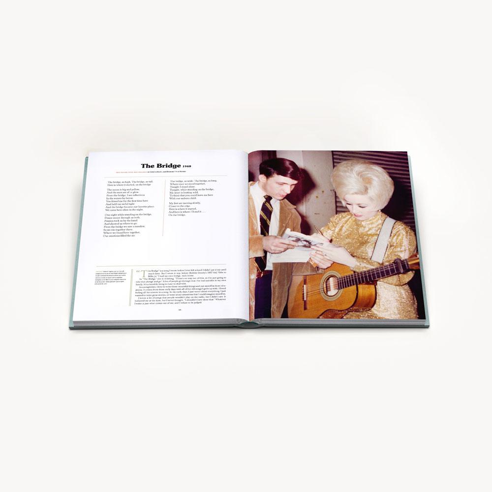 Two hardcover books titled "Songteller: My Life in Lyrics" by Dolly Parton, displayed with the front cover and spine visible, featuring images and text related to Dolly Parton&