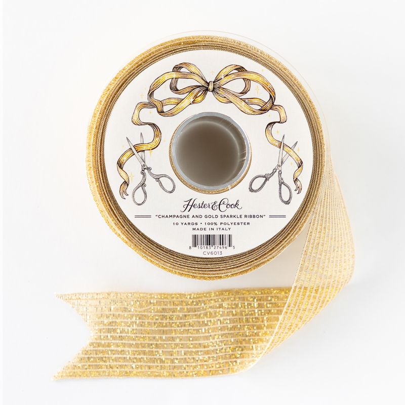 Gold sparkly ribbon on a white spool with scissors and a bow design.