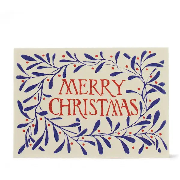 A cream greeting card on a white background featuring red text reading Merry Christmas surrounded by blue foliage.