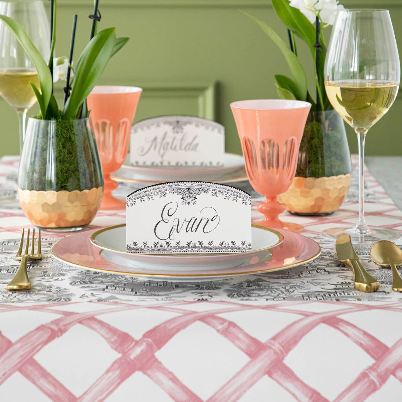 Black Willow Place Card with "Evan" written on it, sitting on dinner plates, on an elegant place setting.