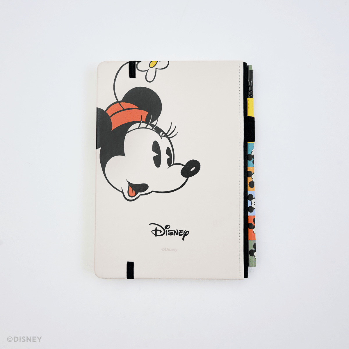 A Disney tablet notebook featuring a playful peeking Minnie Mouse design on the back, shown on a clean white background with colorful page dividers visible on the side.