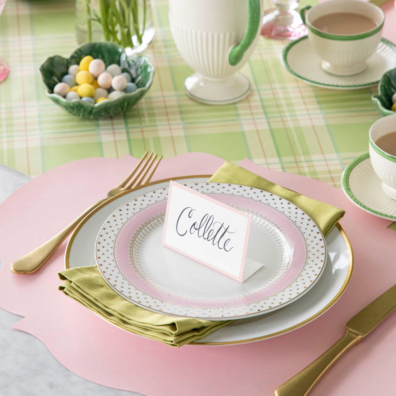 Pink Frame Place Card with "Collette" written in script, on a set of dinner plates on a colorful place setting.