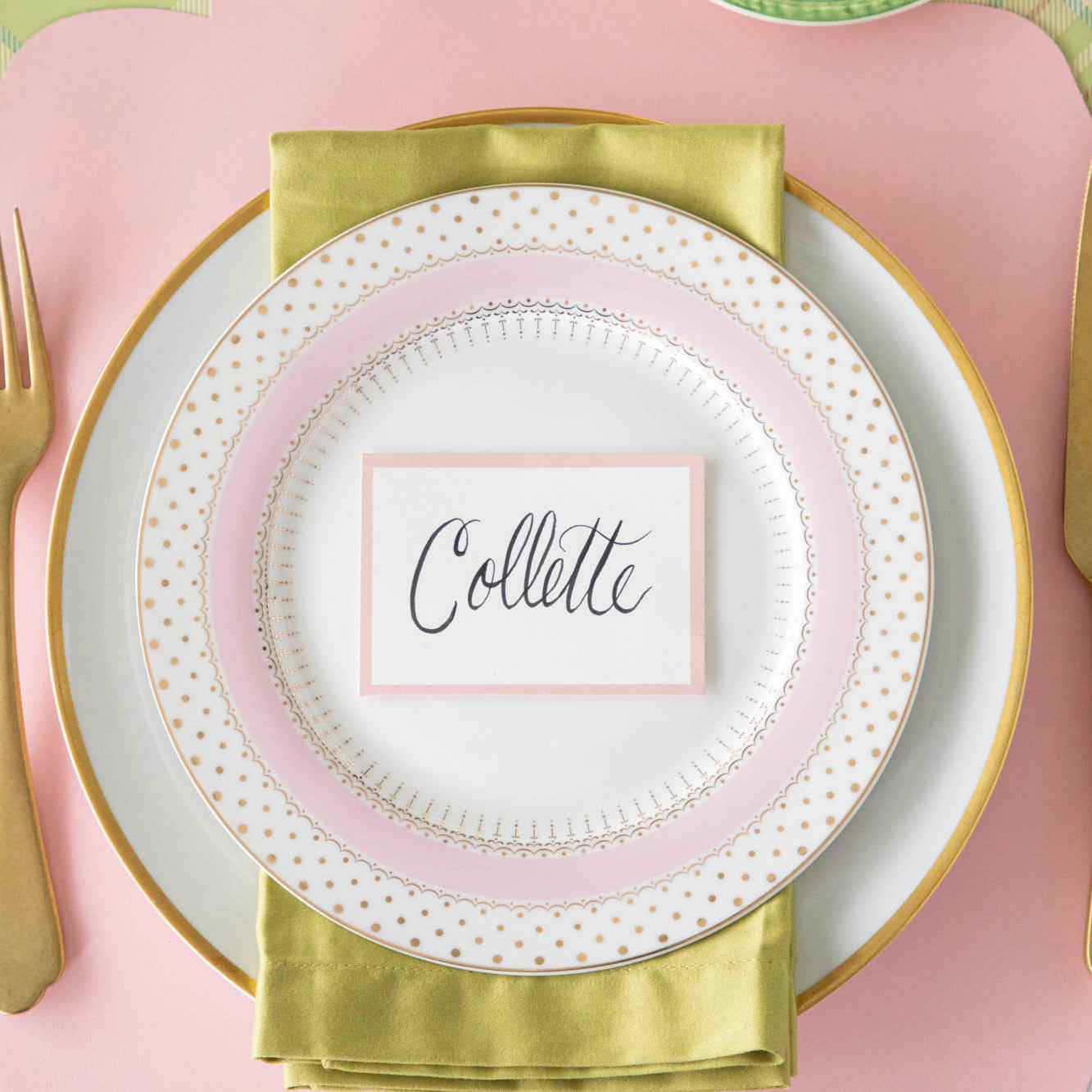 Pink Frame Place Card with "Collette" written in script, on a set of dinner plates on a colorful place setting.