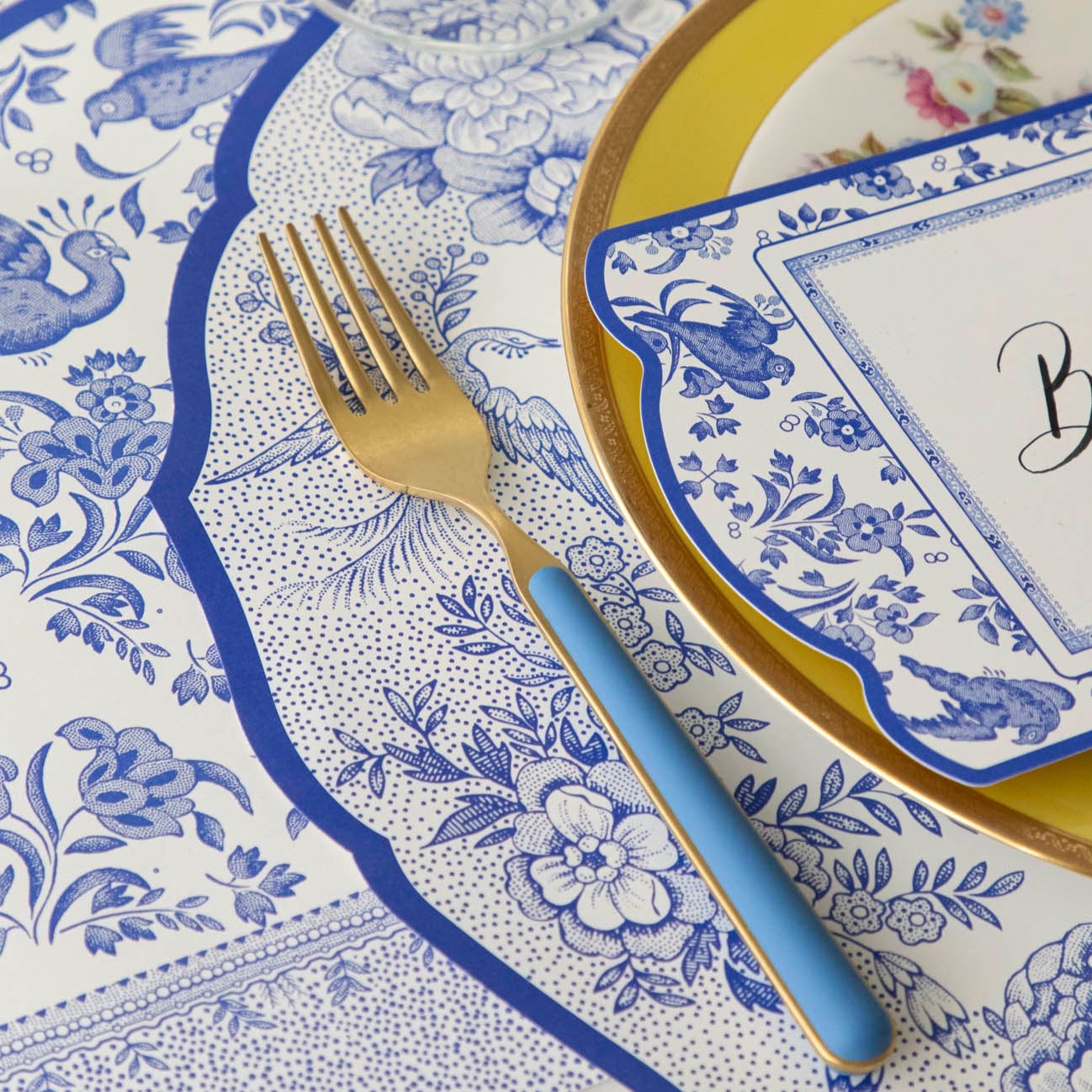 Close-up of the Die-cut Blue Asiatic Pheasants Placemat in an elegant place setting, showing the artwork in detail.