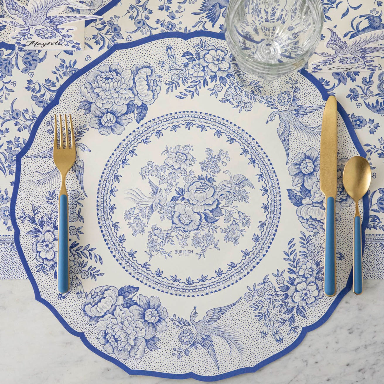 The Die-cut Blue Asiatic Pheasants Placemat in an elegant place setting sans plate, from above.