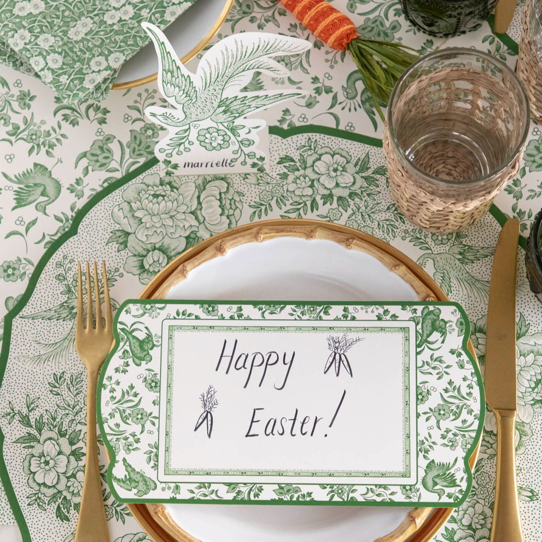 A Hester &amp; Cook Green Regal Peacock Table Card with &quot;Happy Easter!&quot; written on it in cursive resting on a plate.