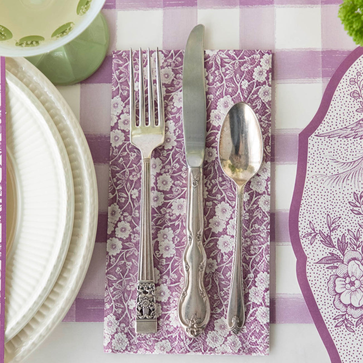 An exquisitely decorated Lilac Calico Napkins on a checkered table setting with beautiful silverware from Hester & Cook.
