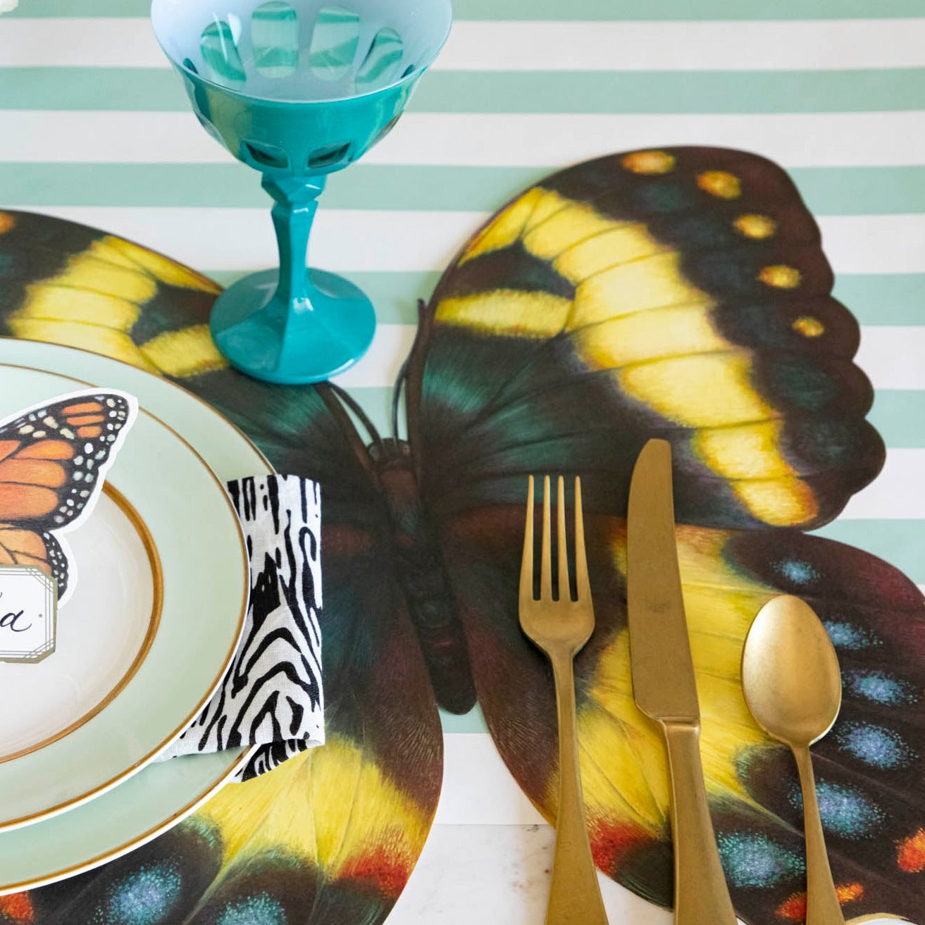 An elegant butterfly-themed place setting on a Die-cut Butterfly Placemat.