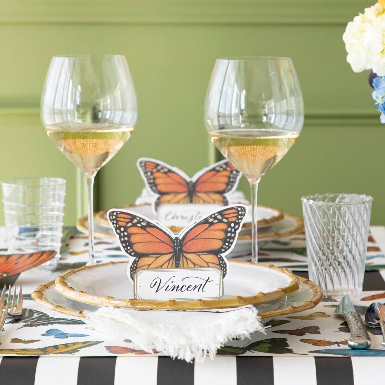An elegant butterfly-themed tablescape featuring Monarch Butterfly Place Cards standing on each plate.