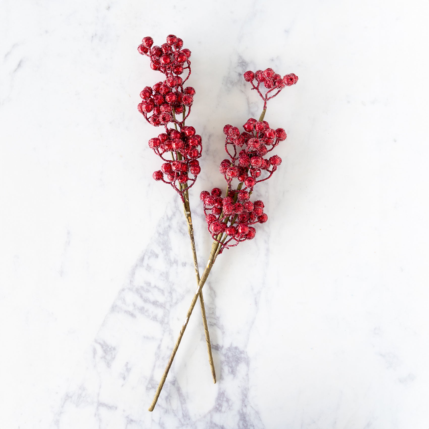 Two Red Cranberry Red Iced Picks on a marble surface.