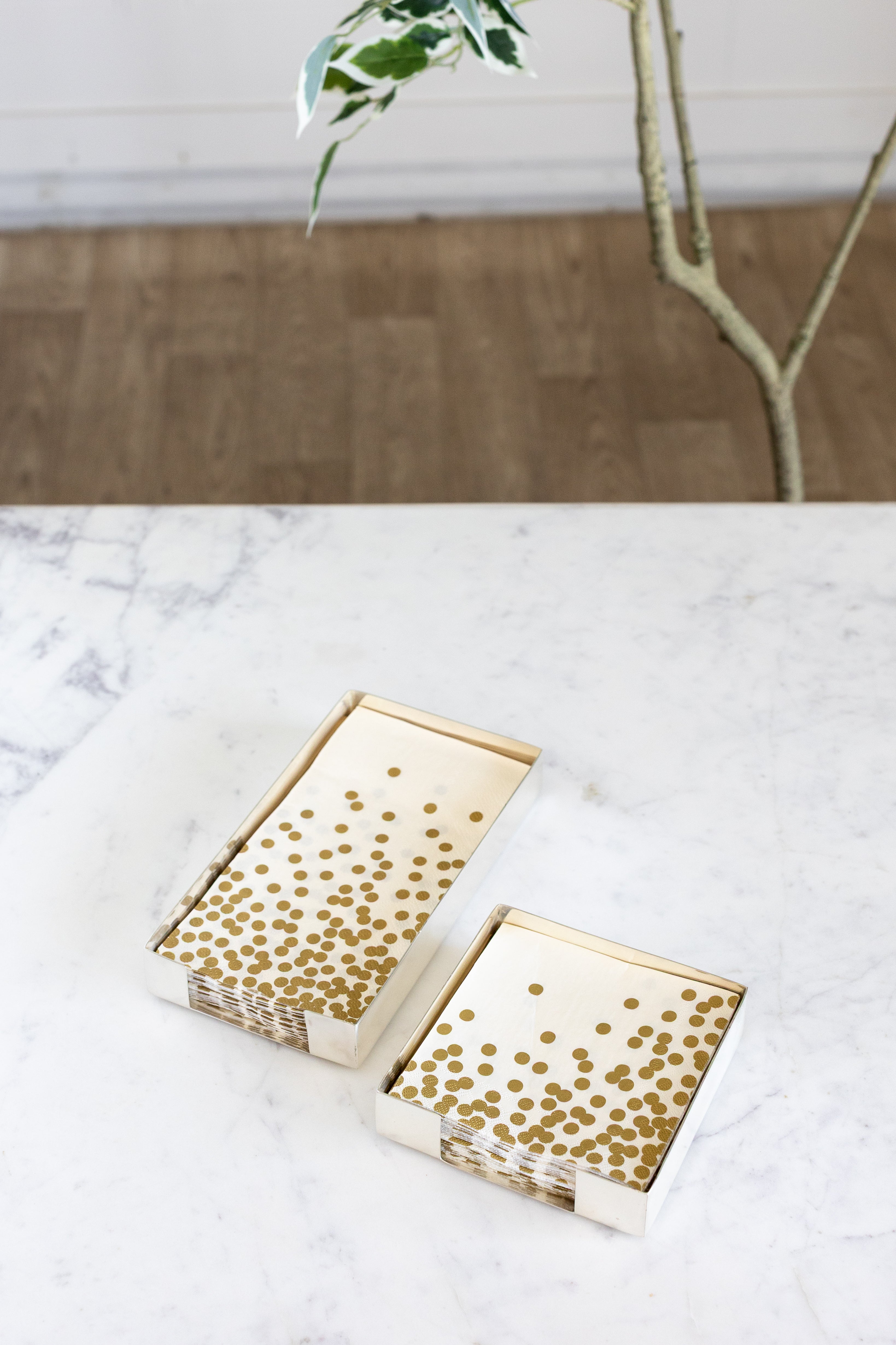 Two Silver Napkin Holders, guest-sized and cocktail-sized, containing napkins on a white table.