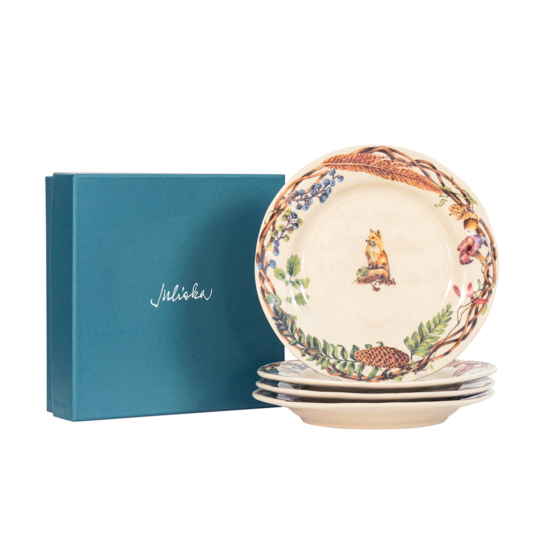 A stack of Forest Walk Gift Plate Sets by Juliska and a blue book.