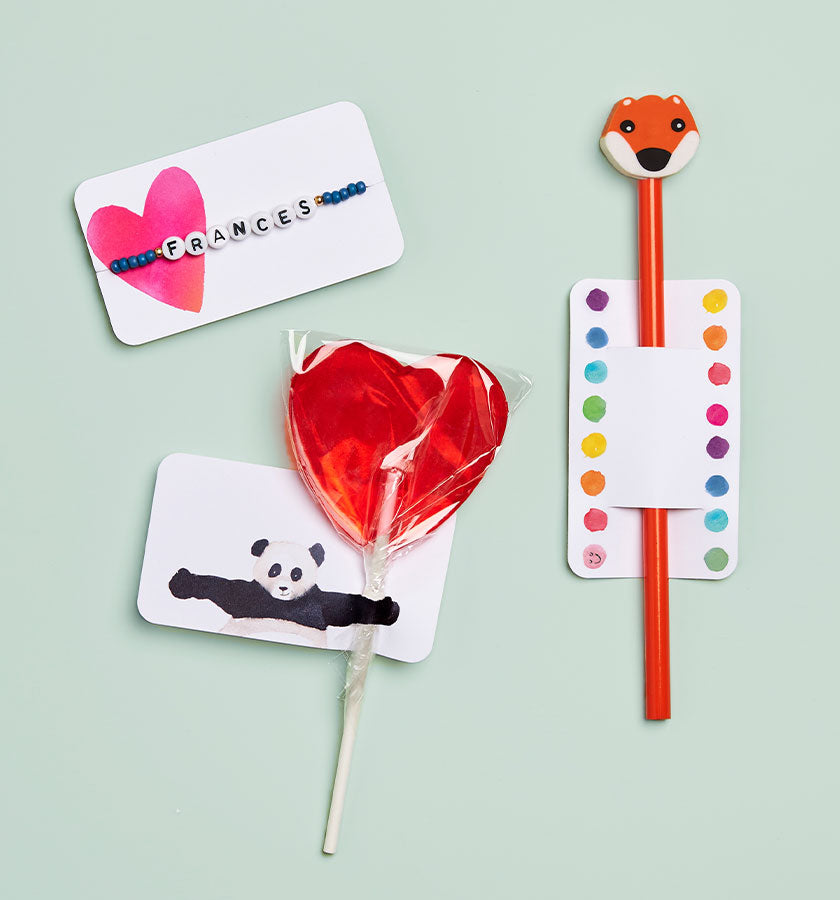 Heart-shaped lollipop attached to a Panda Little note, fox-themed straw inside of a little note and beaded bracelet tied around a heart little note.