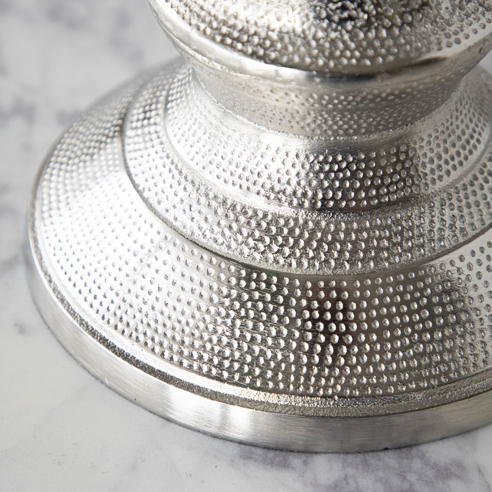 A close up of the base of the Candle Hurricane Holder showing its pressed in dotted details.