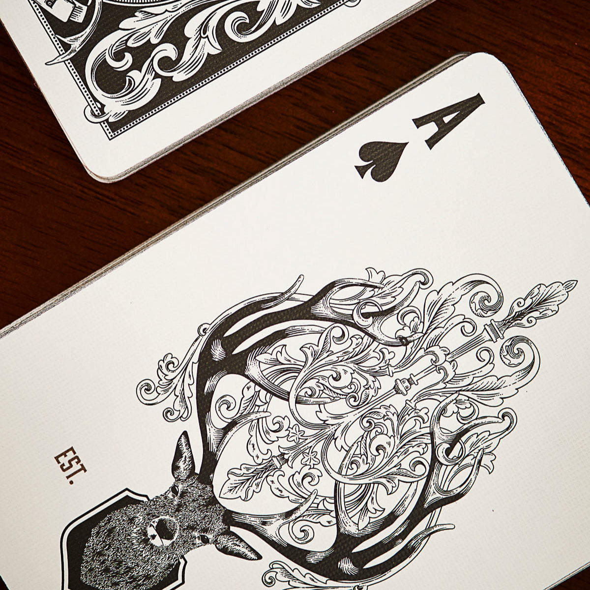 Playing card with intricate black and white design on a wooden surface.