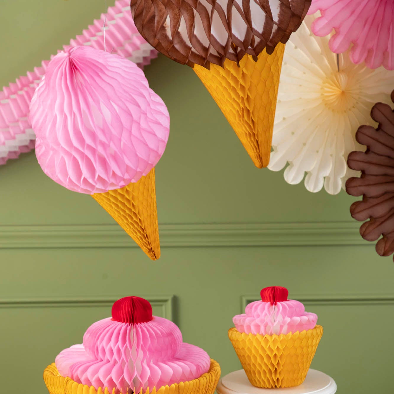 Honeycomb Large Ice Cream Cones hanging from the ceiling above honeycomb cupcakes.