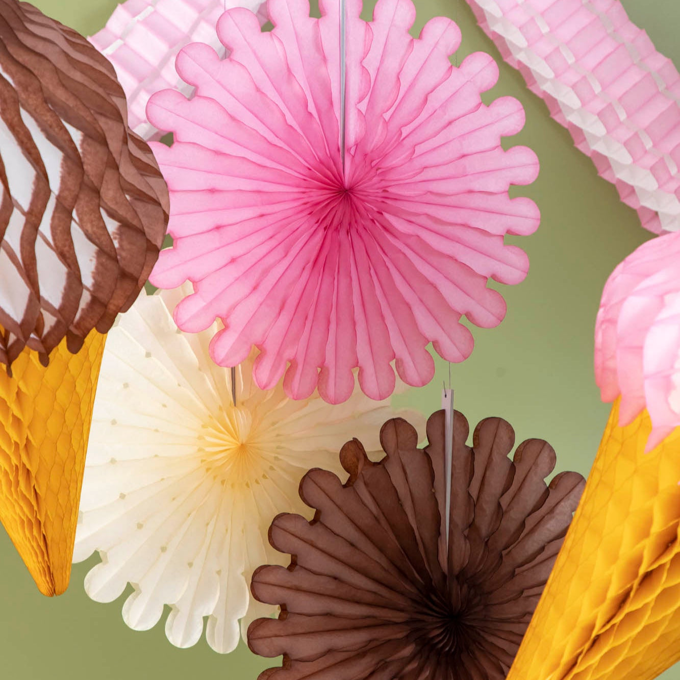 Honeycomb Celebration Fan Set of 3 hung from the ceiling amongst other honeycomb.