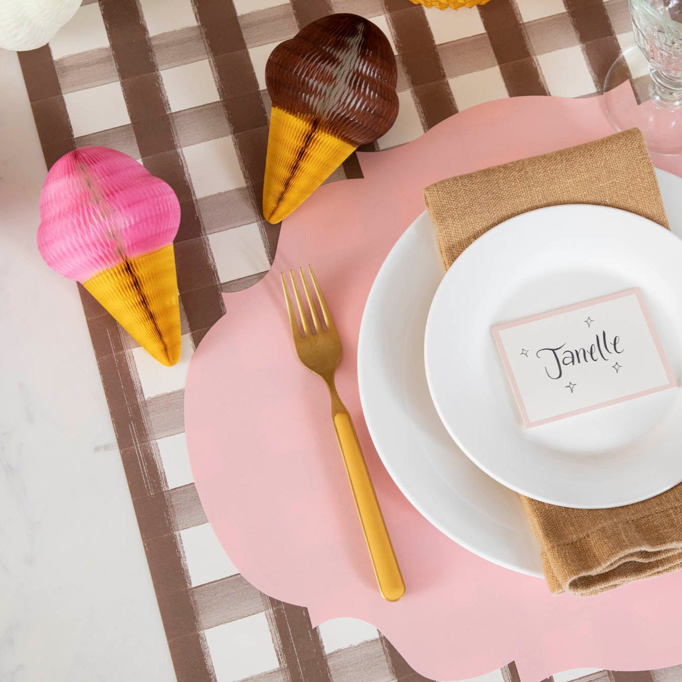Honeycomb Small Ice Cream Cone in chocolate and strawberry, behind a place setting for one.