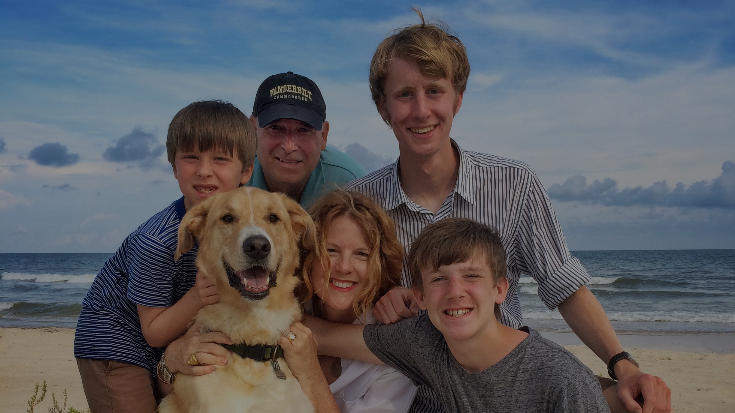 The Cook Family on a beach, smiling.