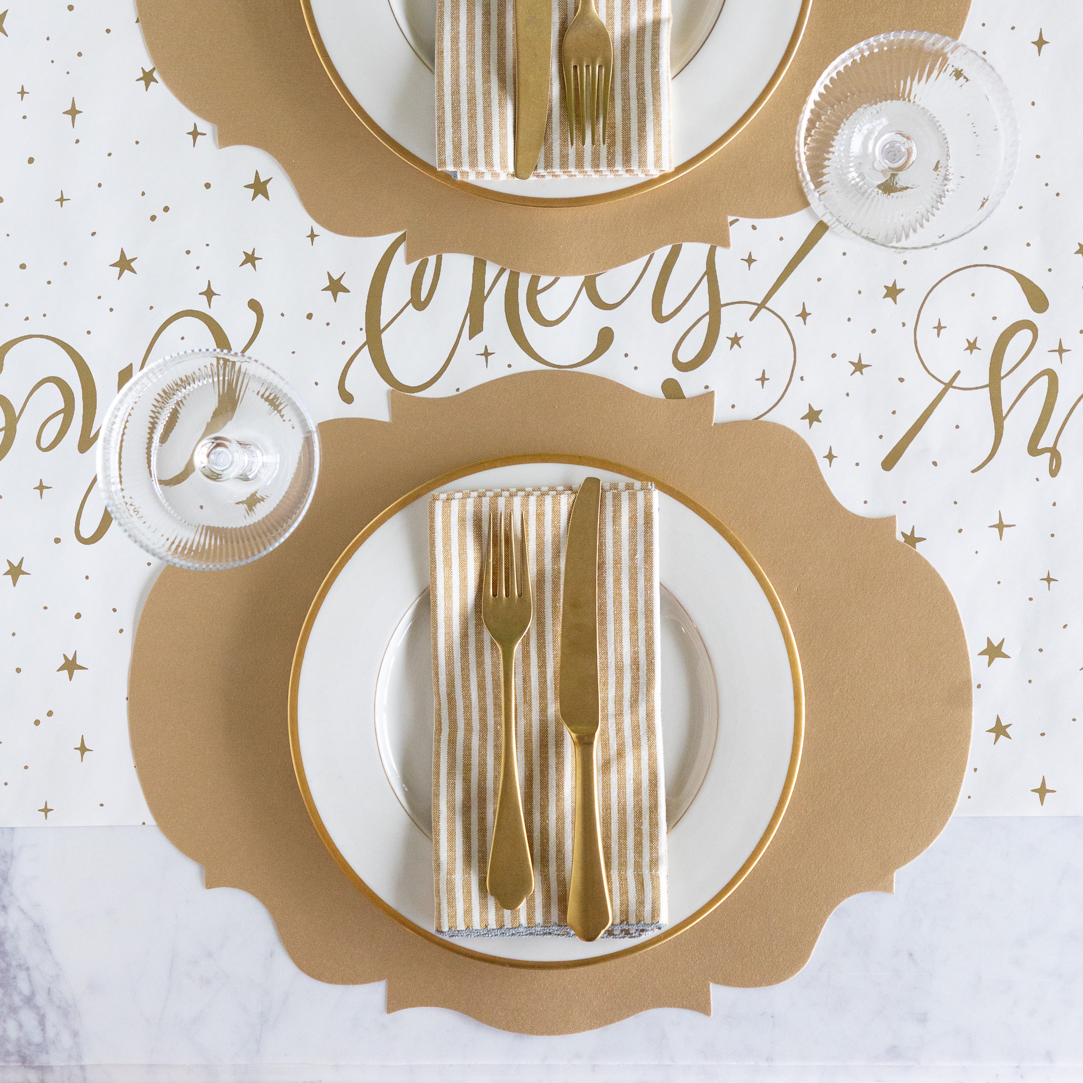 Gold and white place settings with cutlery on a decorative background