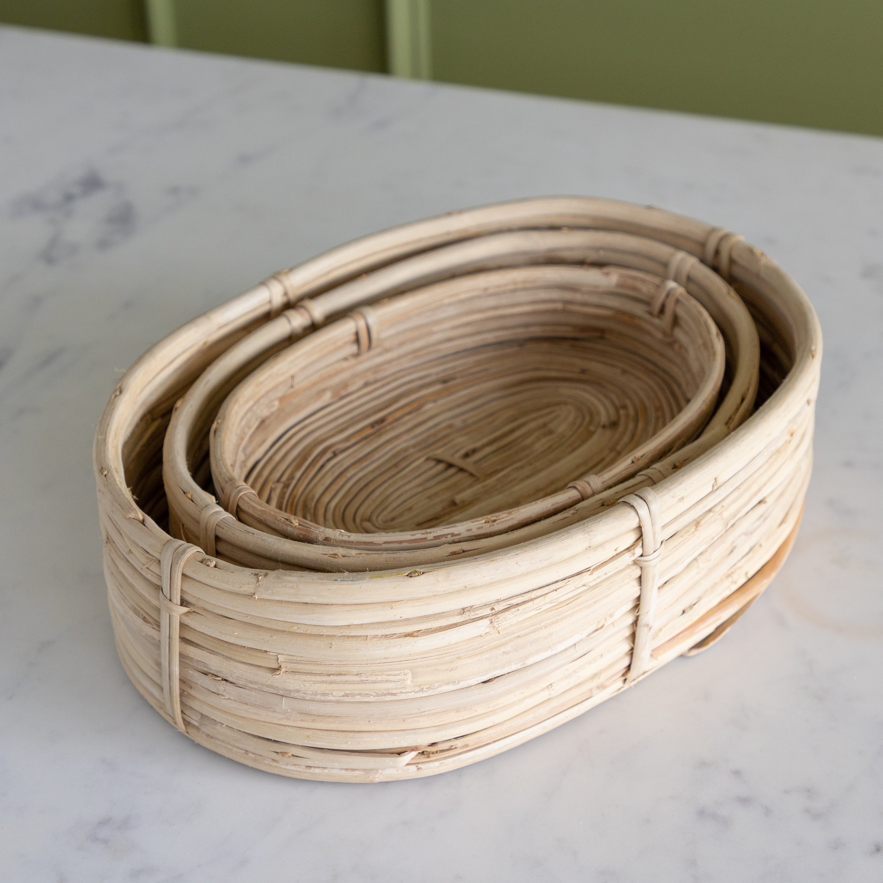 Set of three woven baskets on a marble surface